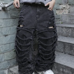 Men's black jeans. With a design of (ripped holes) and tassels. In a street trend style.